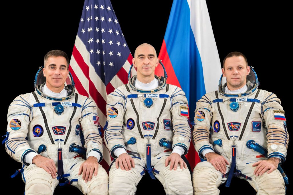 NASA Astronaut and Expedition 63 Commander Chris Cassidy pictured with Russian Cosmonauts Anatoli Ivanishin and Ivan Vagner in Sokol space suits, representing the international cooperation and shared objectives of the Soyuz MS‑16 mission to the International Space Station.